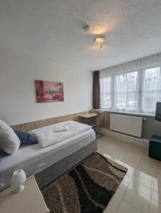 a bedroom with a bed and a television and a rug at Hotel Eiserner Anton in Bielefeld