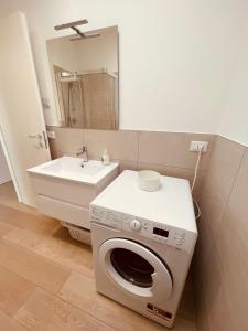 a bathroom with a washing machine and a sink at JESOLO GROUND FLOOR FLAT WITH POOL - 2 family apartments in Lido di Jesolo