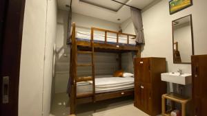 En eller flere senge i et værelse på Suwardika Homestay & Dormitory