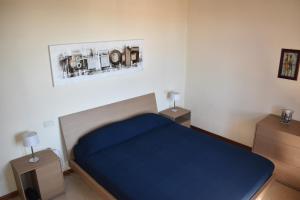 1 dormitorio con 1 cama azul y 2 mesitas de noche en Esclusivo trilocale con piscina al Garda Resort Village, en Peschiera del Garda