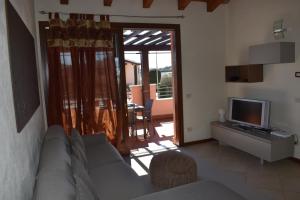 uma sala de estar com um sofá e uma televisão em Esclusivo trilocale con piscina al Garda Resort Village em Peschiera del Garda
