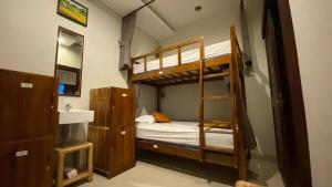 a bedroom with two bunk beds and a sink at Suwardika Homestay & Dormitory in Sanur