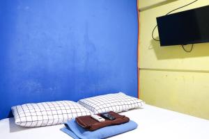 Tempat tidur dalam kamar di Cosmo Tanjung Duren Mitra RedDoorz
