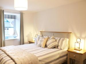 una camera da letto con letto, cuscini e finestra di The Loft a Minehead