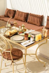 Riad Rahal في مراكش: طاولة مع طعام وأريكة في غرفة المعيشة