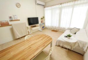 ein Wohnzimmer mit einem Sofa und einem Tisch in der Unterkunft 清清長屋包棟民宿 Ding House in Altstadt von Hengchun