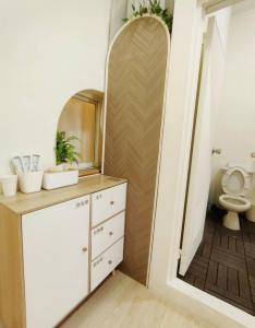 a bathroom with a toilet and a mirror at 清清長屋包棟民宿 Ding House in Hengchun