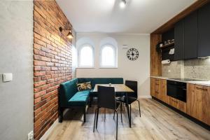 a kitchen with a table and chairs and a brick wall at Młyn Wrocław 10/8 in Wrocław