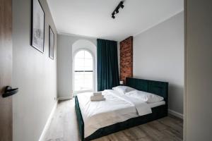 1 dormitorio con 1 cama grande y ventana en Młyn Wrocław 10/8, en Wroclaw