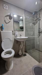 y baño con aseo, lavabo y ducha. en Montenegro Hostel 4U, en Kotor