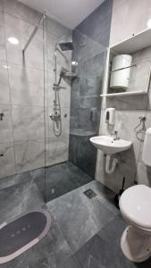 a bathroom with a shower and a toilet and a sink at Montenegro Hostel 4U in Kotor