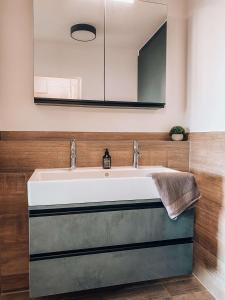 een badkamer met een wastafel en een spiegel bij Sonnenhof Apartments in Kressbronn am Bodensee