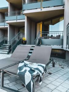 a chair on a patio in front of a building at Sonnenhof Apartments in Kressbronn am Bodensee