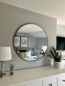 a mirror on a wall with a bed in a bedroom at Prince Arthur Apartment in Walton on the Hill
