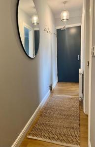 a hallway with a mirror on the wall and a rug at Prince Arthur Apartment in Walton on the Hill