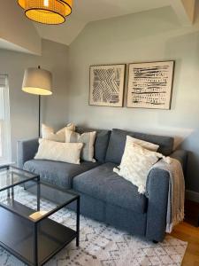 a living room with a blue couch and a table at Prince Arthur Apartment in Walton on the Hill