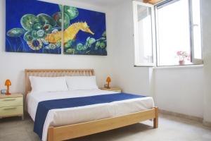 una camera da letto con un letto e un dipinto sul muro di Acquamarina di Mancaversa a Marina di Mancaversa