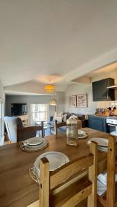 a kitchen and living room with a wooden table with chairs at Prince Arthur Apartment in Walton on the Hill