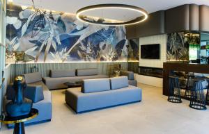 a lobby with blue couches and a large painting at Marinus Beach Hotel in Marina