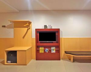 um quarto com uma televisão e uma máquina vermelha em Asyana Sentul Bogor em Bogor