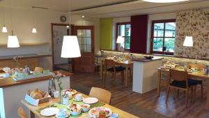 una cucina e una sala da pranzo con tavoli e sedie di Ferienwohnungen Familie Neubert a Nordheim