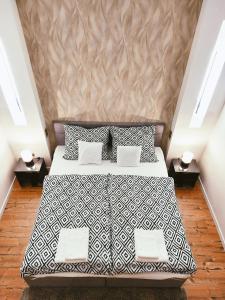 1 dormitorio con 1 cama con sábanas blancas y negras en SQUARE 16 Apartman - Absolutely Central Location with Self Check In, en Szombathely