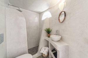Baño blanco con lavabo y aseo en Cozy Cave Studio en Emporio Santorini