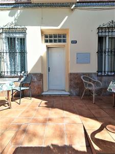 un patio con sedie e una porta in un edificio di El Palo Estudio a Málaga