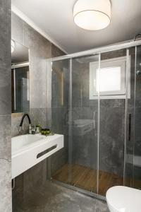 a bathroom with a shower and a sink and a toilet at The Greystone House by Konnect, Views to the Sea in Nisakion