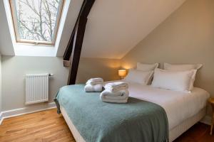una camera da letto con un letto e asciugamani di Domaine Mont-Riant à Jurançon a Jurançon
