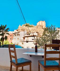 a table with two chairs and a bottle of wine at Casita en el Tajo in Setenil