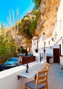 einen Tisch und Stühle auf einer Terrasse mit einem Berg in der Unterkunft Casita en el Tajo in Setenil de las Bodegas