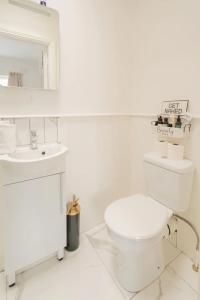 a white bathroom with a toilet and a sink at Unique & Central 3BD - Dublin City in Dublin