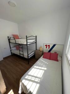 um quarto com uma cama e 2 beliches em Villa Zen, La Barrosa em Cádiz