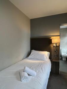 een bed met twee handdoeken in een kamer bij St Andrews Town Hotel in Droitwich