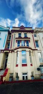a large building with many windows on a street at The Commodore Rooms & Relaxation in Paignton