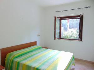1 dormitorio con cama y ventana en Appartamento in Villa con giardino a 200m dal mare, en Vieste
