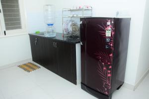 een zwarte koelkast in een kamer met een aanrecht bij Windfall Service Apartment in Bangalore