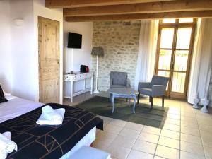 a bedroom with a bed and a table and a desk at Une chapelle en soie in Taulignan