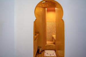 Un arco que conduce a un baño con ducha en riad dar nejma & Spa en Marrakech