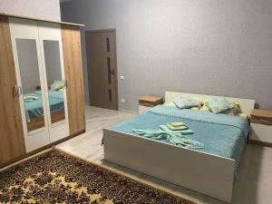 ein Schlafzimmer mit einem Bett und einem großen Spiegel in der Unterkunft Катерина in Chynadiyovo