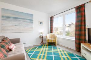 a living room with a couch and a window at The Cooperage - 2 Bedroom, 2 Bathroom with Garden in Crail