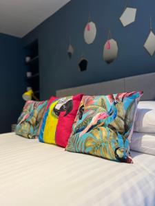 uma cama com duas almofadas coloridas em Stable Yard Rooms em Richmond