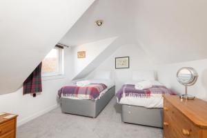 two beds in a room with white walls at The Cooperage - 2 Bedroom, 2 Bathroom with Garden in Crail