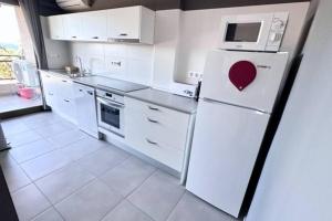 Roses Apartments - Marivent (2rooms) Vistas frontales al mar في روساس: مطبخ أبيض مع ثلاجة عليها قلب +3 صور