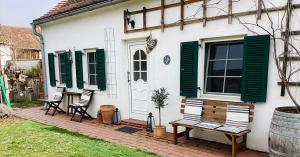a white house with green shutters and a bench at Bed & Breakfast Chez Lips in Oberbildein