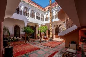een binnenplaats in een gebouw met bomen en tapijten bij riad dar nejma & Spa in Marrakesh
