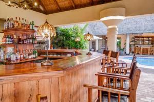 a bar in a resort with a swimming pool at Ilala Lodge Hotel in Victoria Falls