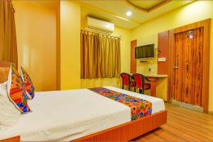 a hotel room with a bed and a table and chairs at FabHotel AG Star in kolkata