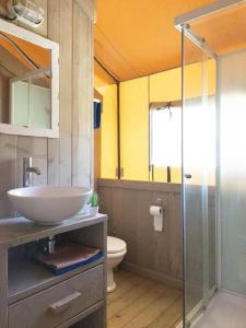 a bathroom with a sink and a glass shower at Glamping tent with bathroom - Tuscany next to sea! in Viareggio